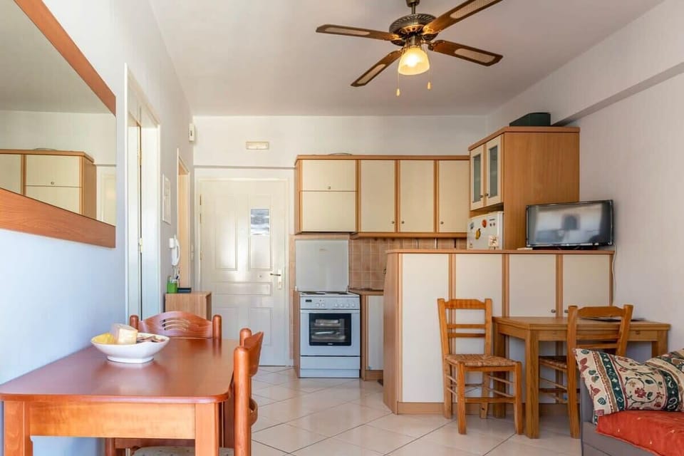 Open Kitchen and Dining Area with Ceiling Fan
A functional layout combining a full kitchen and wooden dining set, complete with a ceiling fan for added comfort.