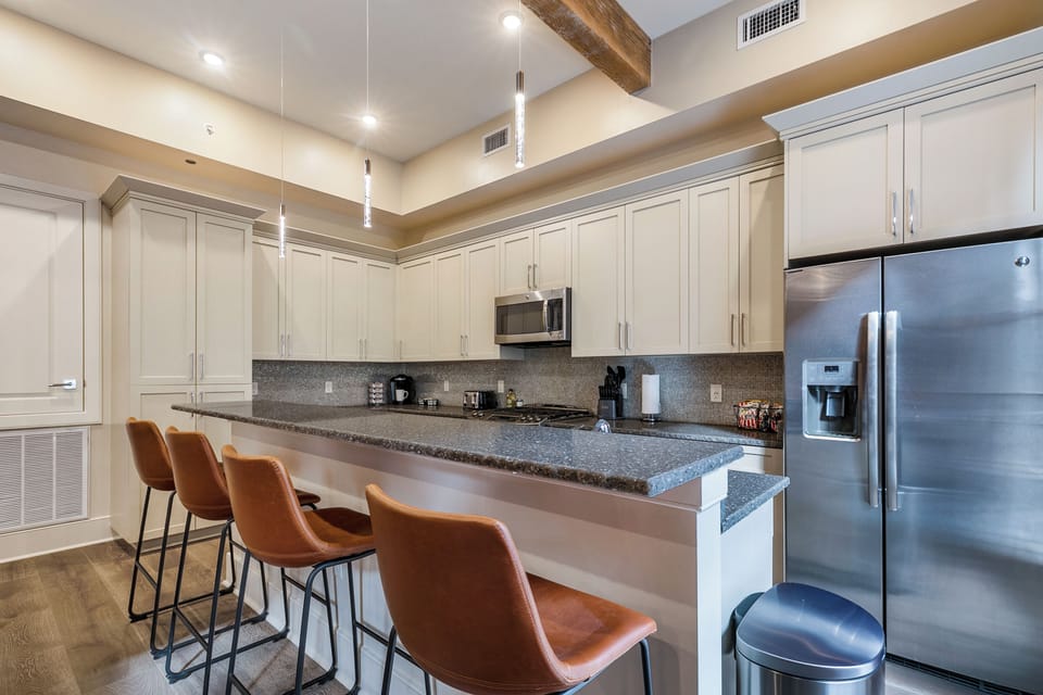 Cook and dine easily in the fully stocked kitchen, equipped with all stainless steel appliances, gas range, basic cookware, and a dining area for a comfortable meal at home. Entertain at the bar with seating for four.