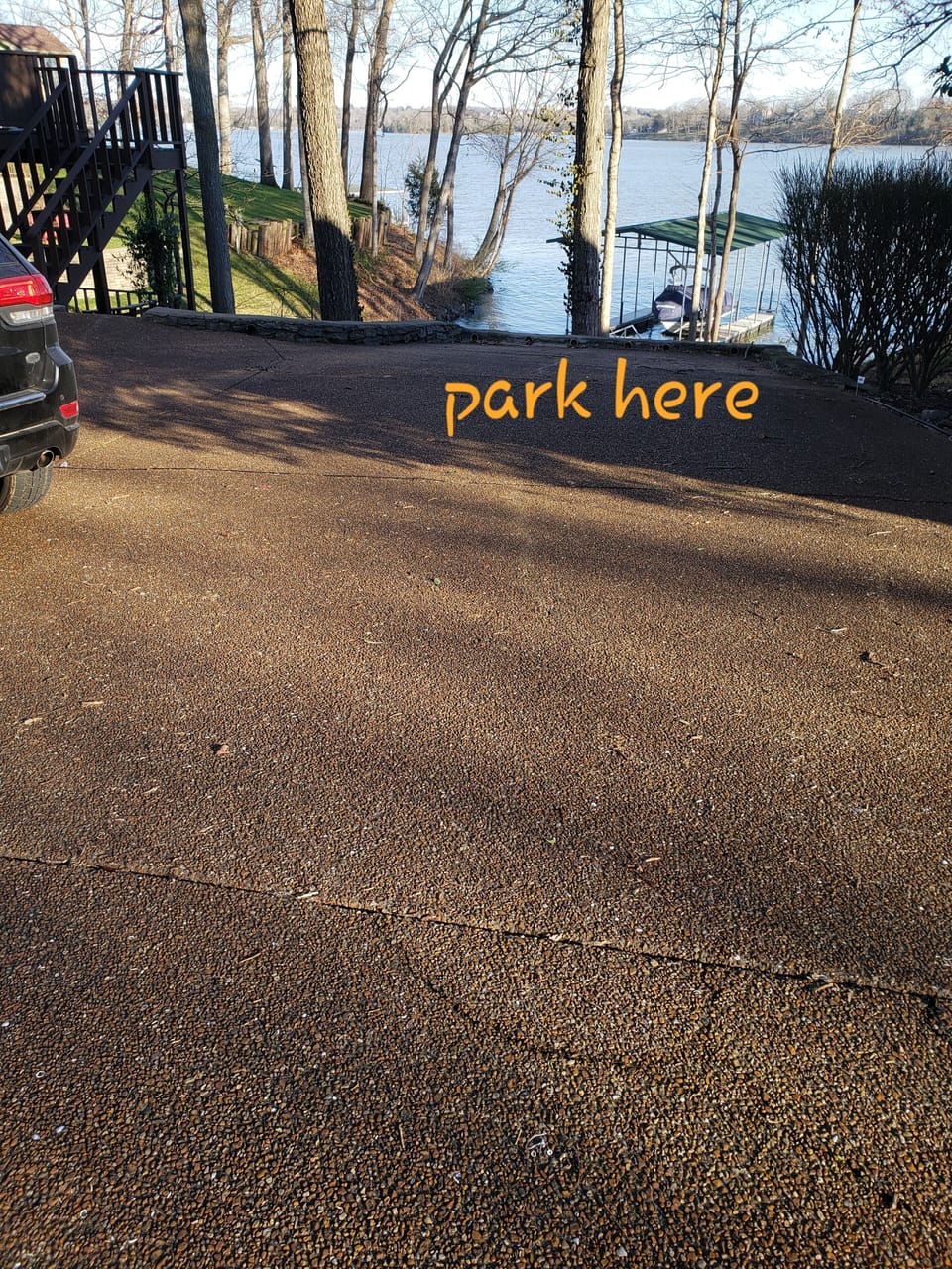 park at the bottom of the driveway facing the dock.