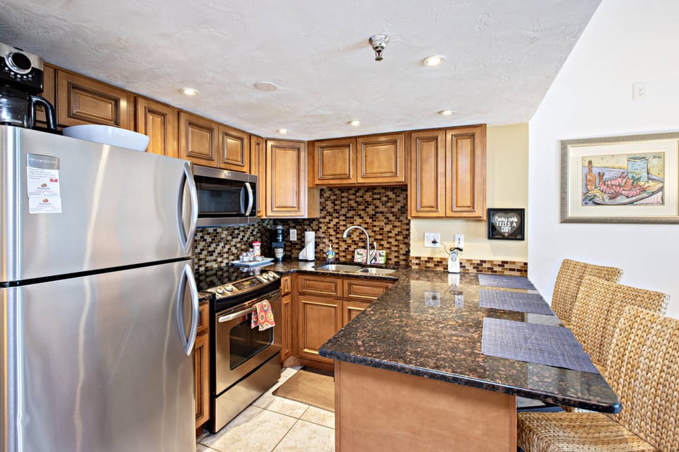 ...equipped with refrigerator w/ ice-maker, dishwasher, glass stove/oven, microwave, coffee maker, toaster, blender, etc.