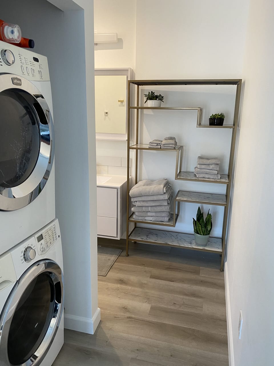 Hall to bathroom with stackable washer and dryer.