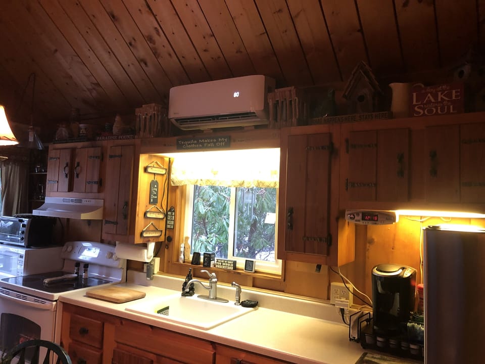 Kitchen showing air conditioner / heater, Kerrigan coffee pot, with coffee pods.