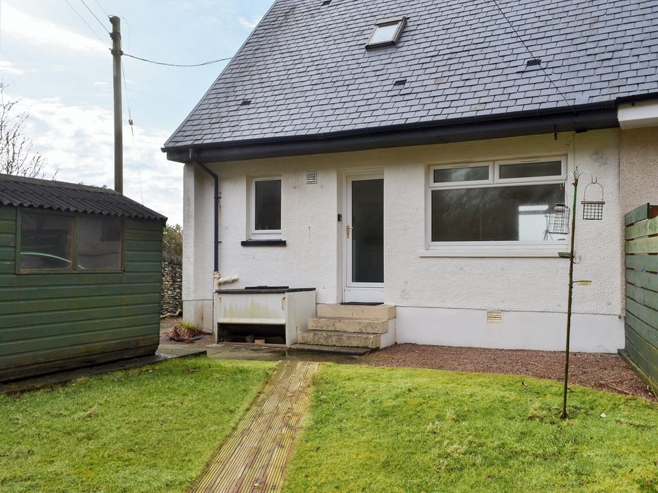 Small enclosed, lawned garden with garden furniture | Seaview Cottage, Ellenabeich, near Oban