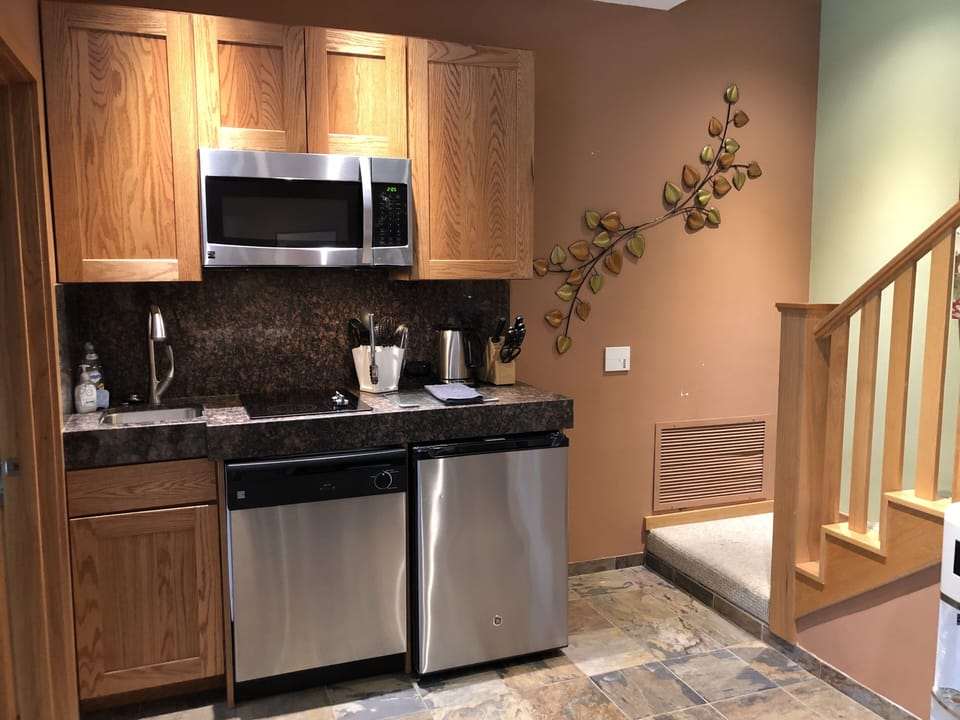 Kitchenette with small refrigerator, microwave, 2 burner stove, dishwasher, sink