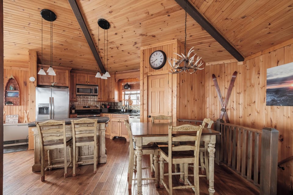 Cook and gather with ease in this open-concept kitchen featuring modern appliances, rustic charm, and a spacious dining area.
