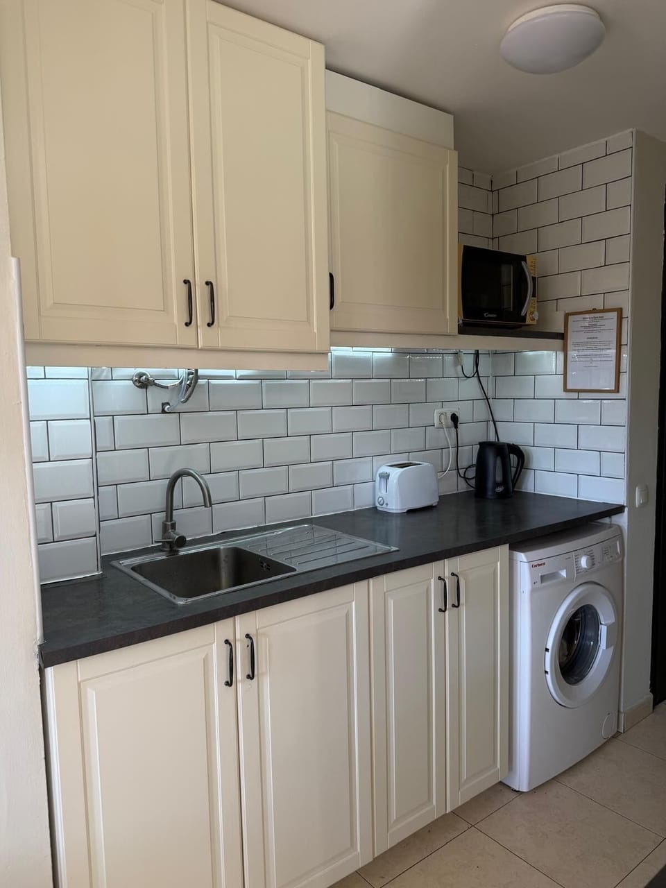 Kitchen fitted with washing machine and microwave 