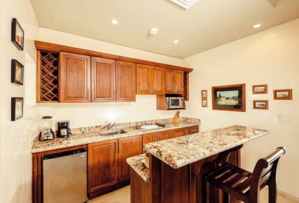 This kitchenette comes equipped with granite counter tops, a microwave, coffee maker, small fridge and stove top. 