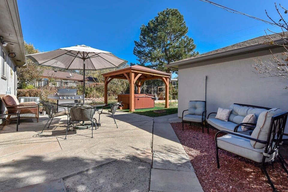Sunny patio setup with an umbrella table and cushioned outdoor seating—an easy spot to linger over lunch and unwind in the fresh air.