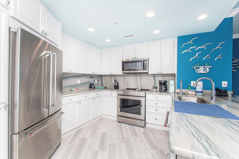 Your coastal-inspired kitchen awaits with sleek granite countertops, stainless appliances, and ocean-blue accents that make meal prep feel like seaside bliss.