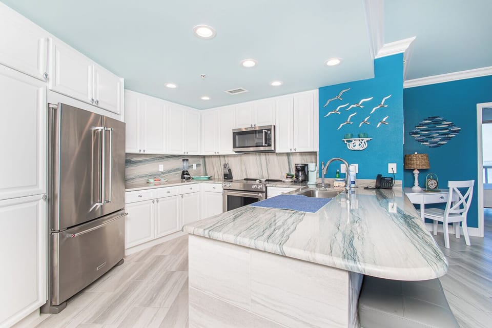 Your fully-equipped kitchen features gleaming granite counters, stainless steel appliances, and ocean-themed touches that make cooking feel like a coastal retreat.