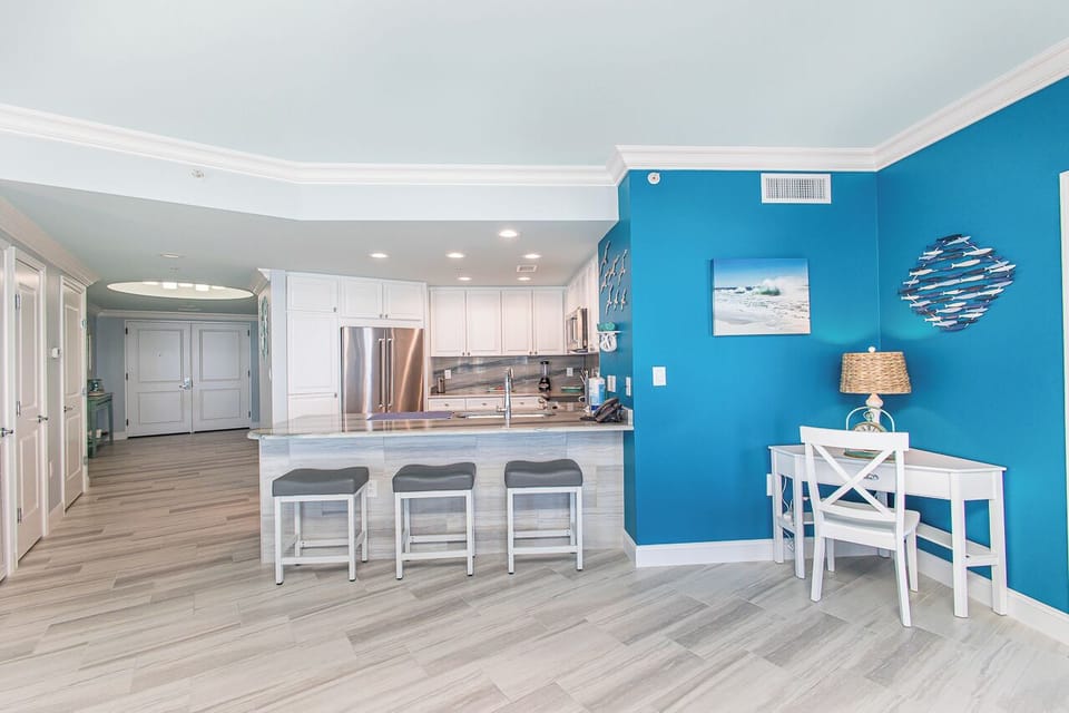 Your open kitchen features vibrant blue accent walls and a spacious island with seating, perfect for preparing meals together.