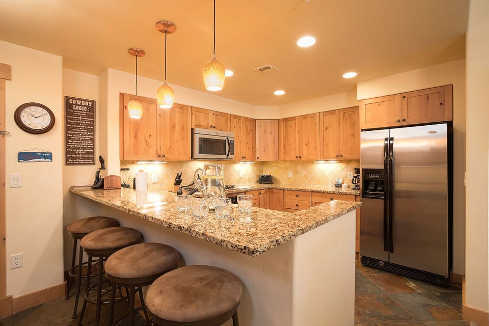 Your fully equipped kitchen features granite counters, stainless appliances, and a breakfast bar where you can enjoy morning coffee together.