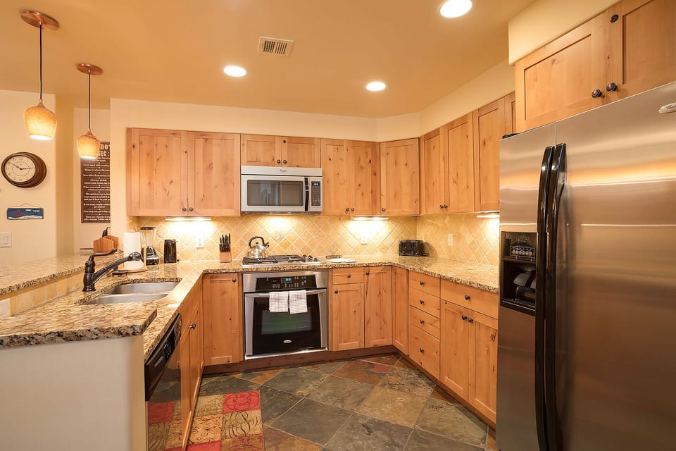 Cook memorable meals in your spacious kitchen with granite countertops, stainless steel appliances, and warm wood cabinetry.