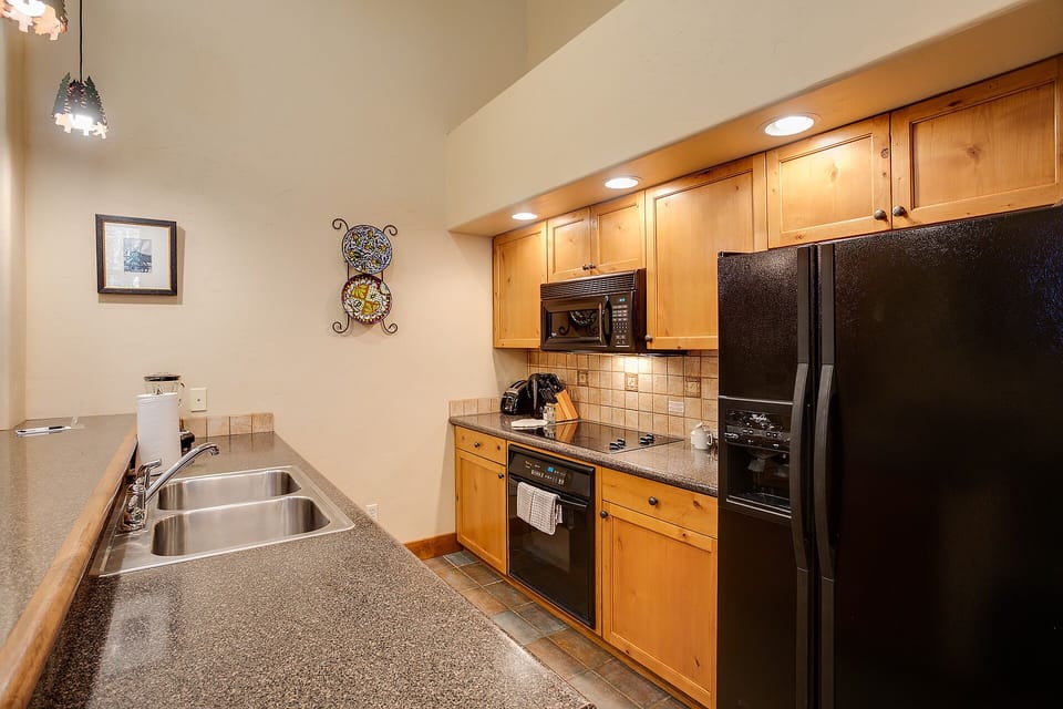 Your fully equipped kitchen features granite counters, stainless appliances, and warm wood cabinetry—everything you need to prepare delicious meals during your stay.
