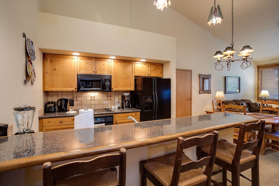 Your fully equipped kitchen features granite counters, stainless appliances, and a breakfast bar perfect for morning coffee or casual meals.