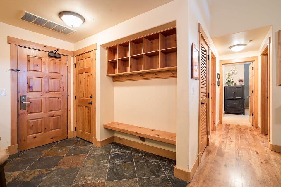 Step into your welcoming entryway with handcrafted wood storage cubbies and bench—perfect for organizing gear after mountain adventures.