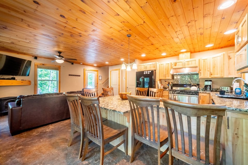 The well-equipped kitchen has a 6-burner gas stove, custom cabinets, and is fully equipped for making meals at home.
