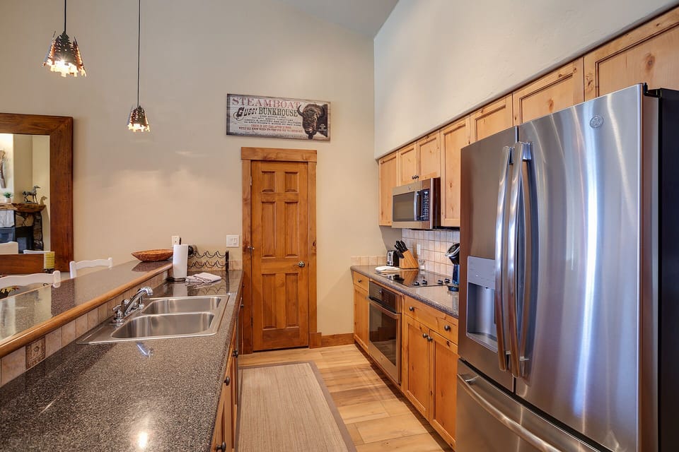 Your fully-equipped kitchen invites culinary adventures with granite counters, stainless steel appliances, and warm wood cabinetry creating a perfect cooking space.
