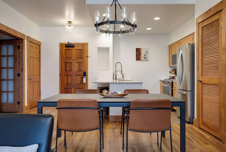 Gather around your spacious dining table where the industrial chandelier casts warm light over home-cooked meals and morning coffee.