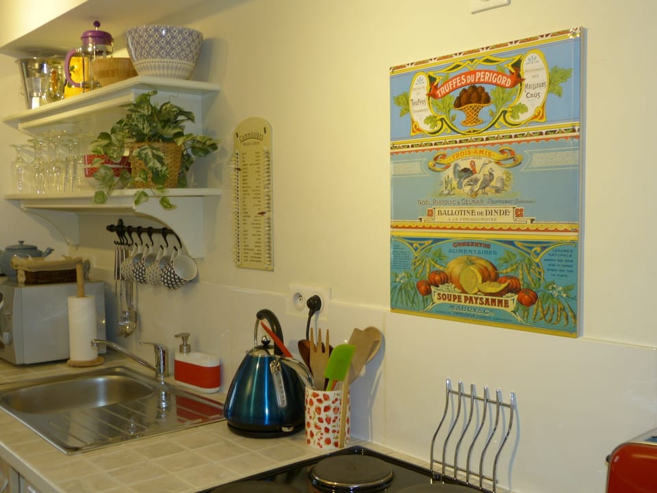 The kitchen has pots and pictures from local markets
