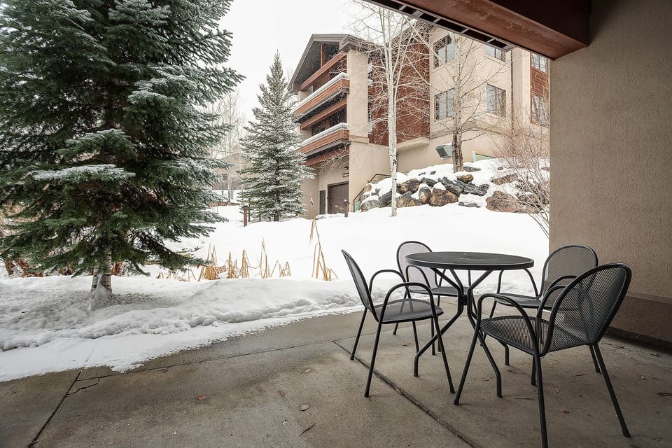 Your private patio offers a peaceful dining spot with serene winter views and comfortable seating for mountain meals.