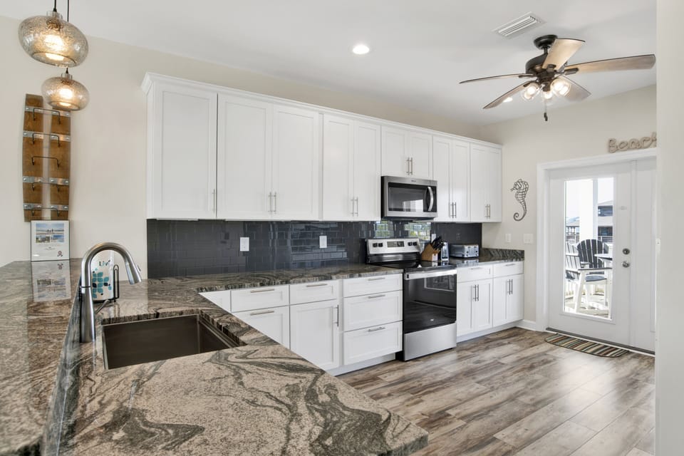 The kitchen is fully equipped and has balcony access with outdoor seating