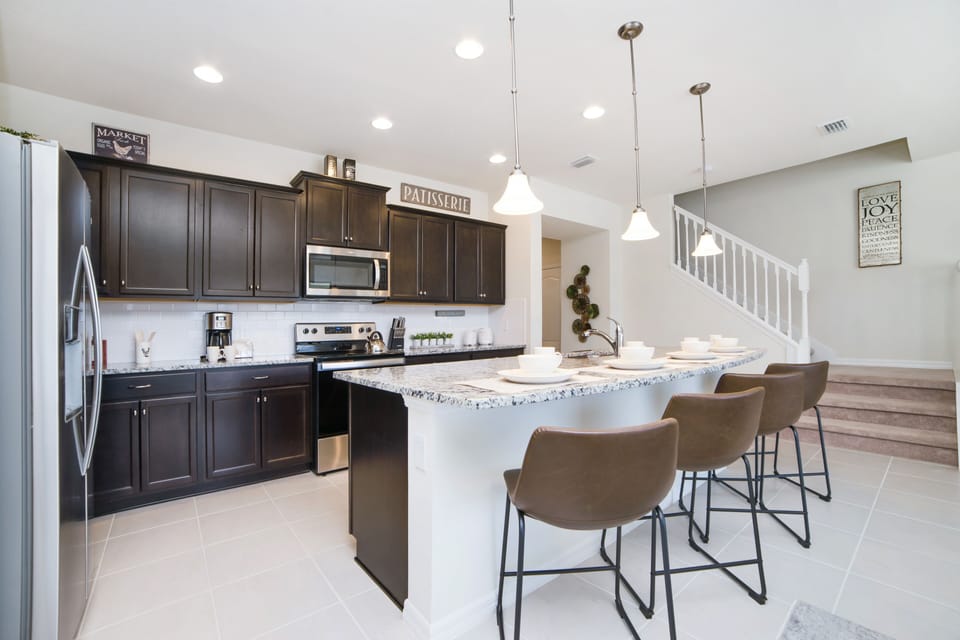 The kitchen, featuring a counter table for added seating space, becomes a culinary and social hub.