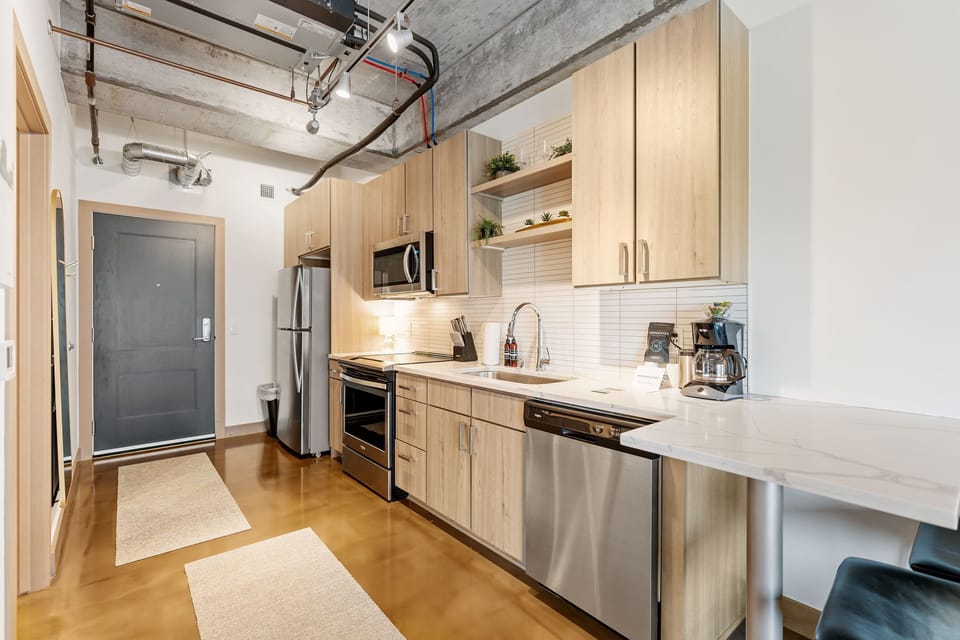 Cook memorable meals in your modern galley kitchen featuring sleek wood cabinets, stainless steel appliances, and plenty of counter space.