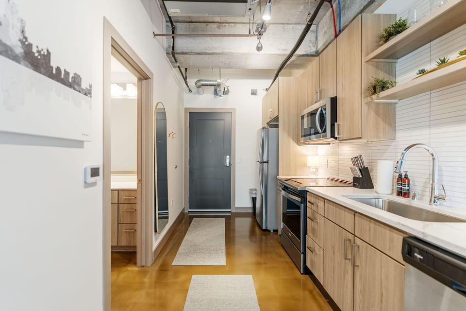 Your modern loft kitchen features sleek wood cabinetry, stainless steel appliances, and an open layout perfect for cooking adventures.