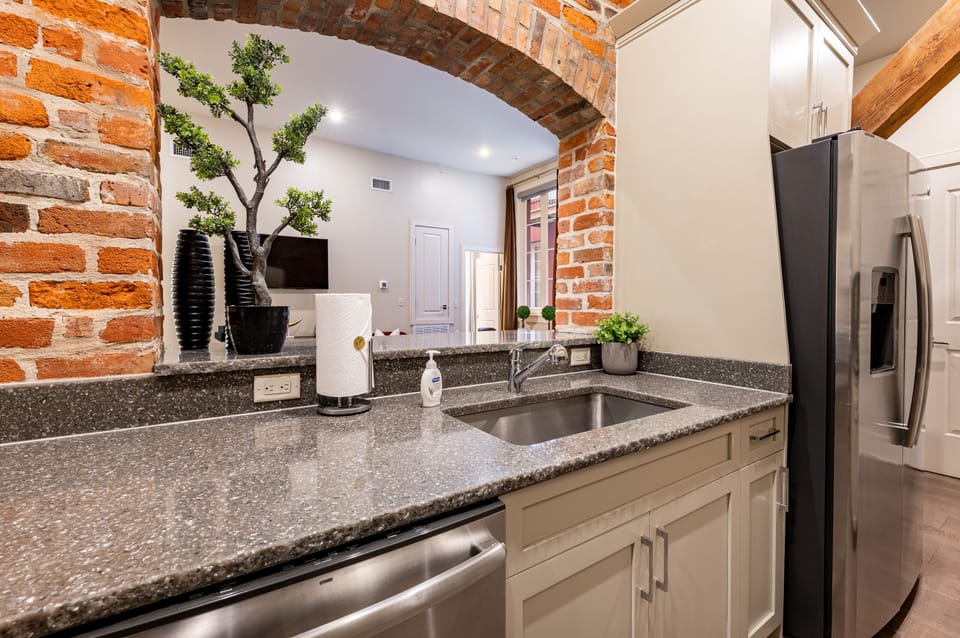 Chef's window to the living room from the kitchen. The exposed brick are a staple of historic New Orleans!