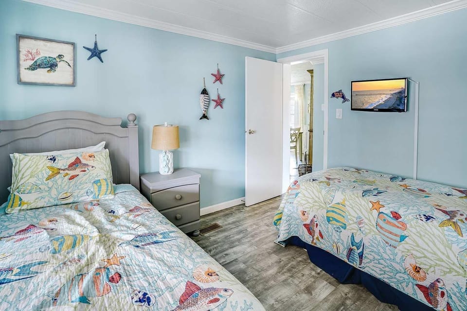 Cozy twin bedroom with coastal-themed decor and natural light