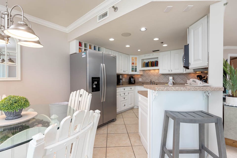 Prepare meals in the bright kitchen featuring stainless appliances, a spacious counter, and a cozy dining area