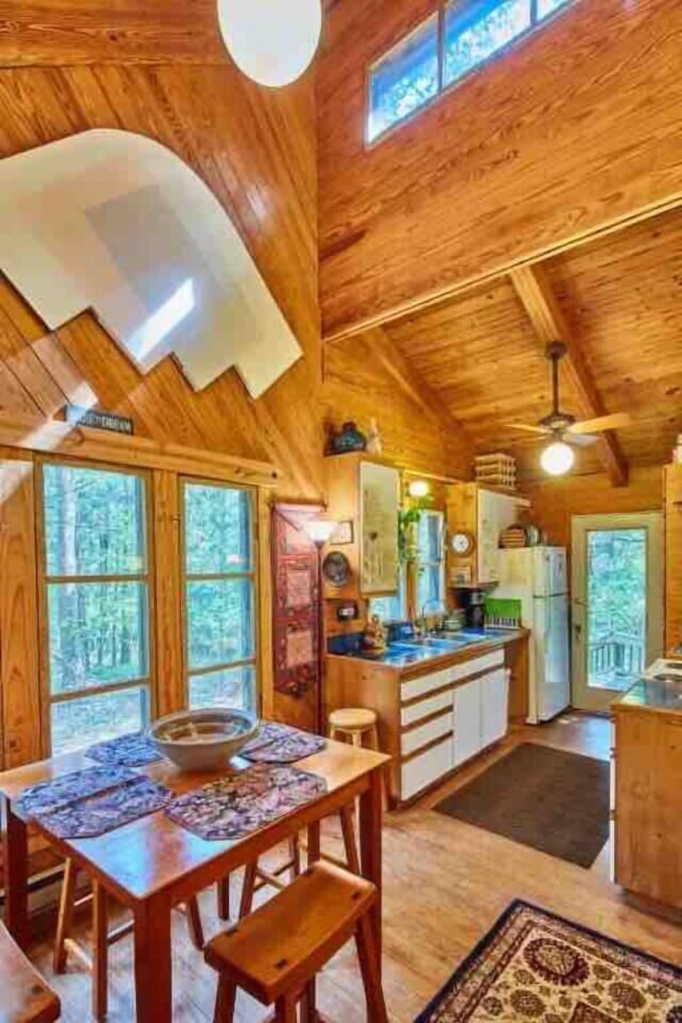 Cabin Dining room with view thru full kitchen & back door to porch, deck, chiminea, creek bed & woods.