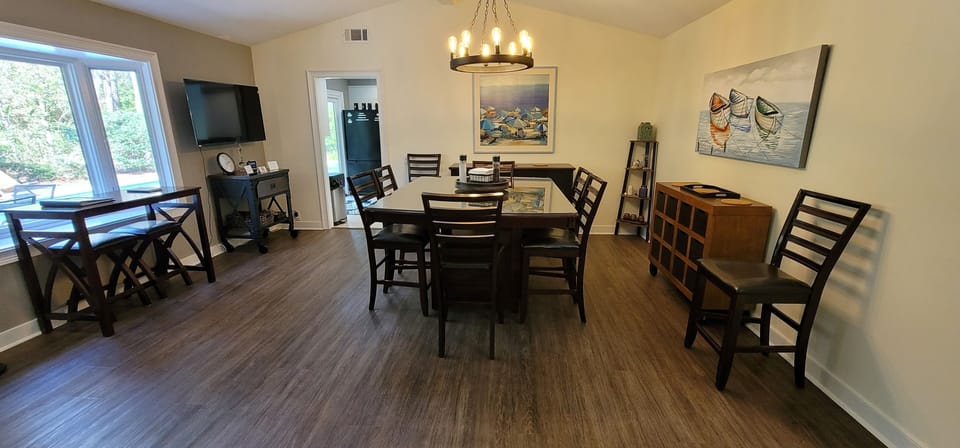 Dining room with a 50" television in the corner.  Seats eight.