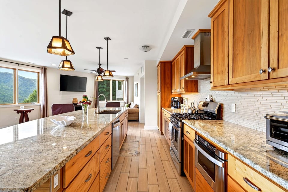 Main-level chef's kitchen with gas range, dishwasher, standard + Keurig coffee makers, and a kitchen island with seating for 6.