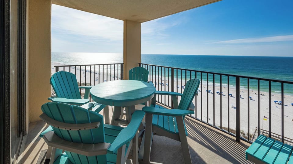 Enjoy a relaxing moment on the balcony with turquoise seating overlooking the beach and sparkling waters