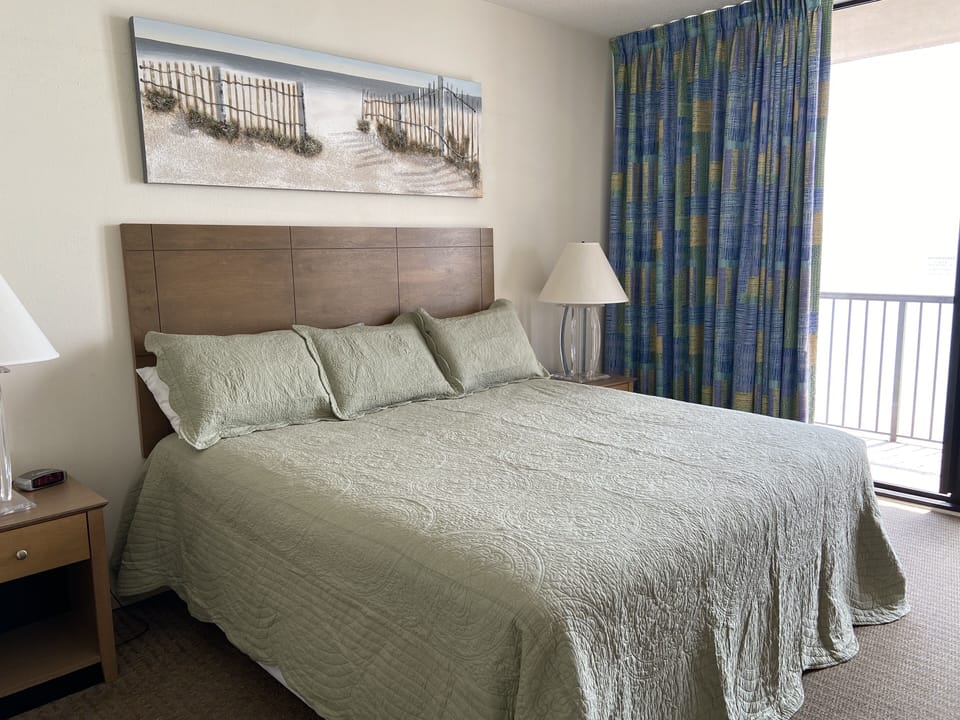 Master Bedroom with King bed, TV/DVD player, lots of storage & balcony access