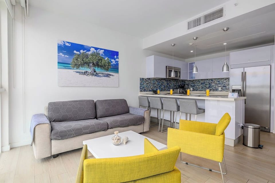 Relax in your bright, open living space where cheerful yellow accents blend seamlessly with a sleek kitchen, perfect for unwinding after a day of island adventures.