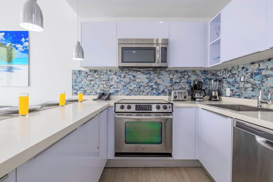 Your bright, fully-equipped kitchen invites you to whip up meals with stainless steel appliances, stunning mosaic tile backsplash, and everything you need for a comfortable stay.