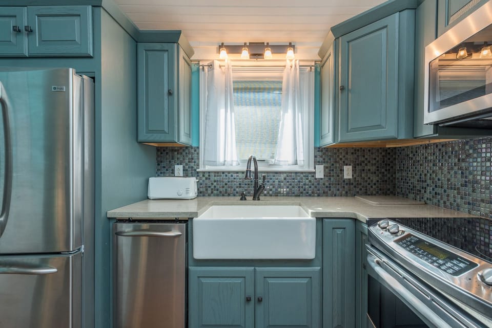 Kitchen with farmhouse sink, dishwasher, and standard drip coffeemaker.
