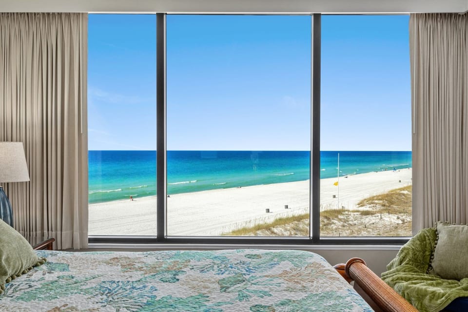 The view from the primary suite is simply unforgettable—wall-to-wall windows frame the emerald Gulf and sugar-white sand, creating a breathtaking backdrop for slow mornings, peaceful nights, and the kind of beachfront escape you will never want to leave.