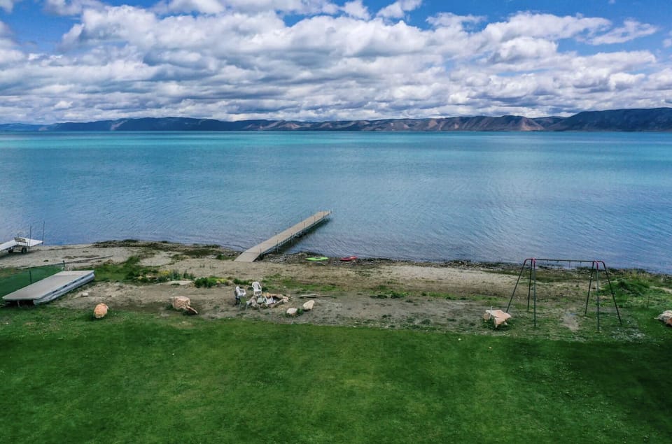 The view of the lawn, lake, fire pit, and dock of Spinnaker Point (from back deck)