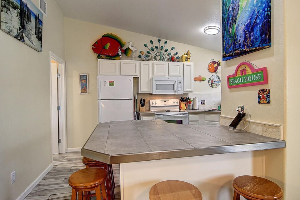 Your beach-themed kitchen features full appliances and a breakfast bar where you can start each morning with coffee and ocean views.