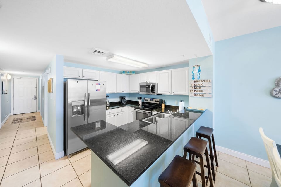 Your fully equipped kitchen features granite countertops, stainless steel appliances, and a breakfast bar where you can enjoy morning coffee.