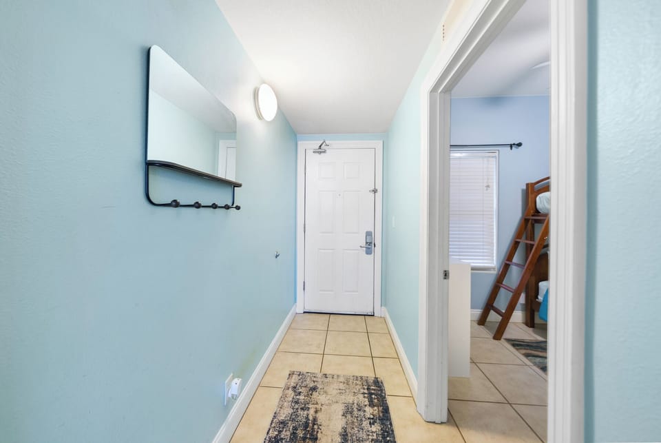 Step into your welcoming entryway with soothing blue walls and convenient hooks for your beach gear.