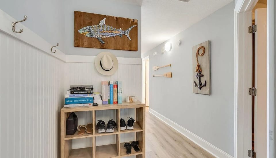 Step into your coastal-themed entryway where nautical art and organized storage create a welcoming first impression for your beach getaway.