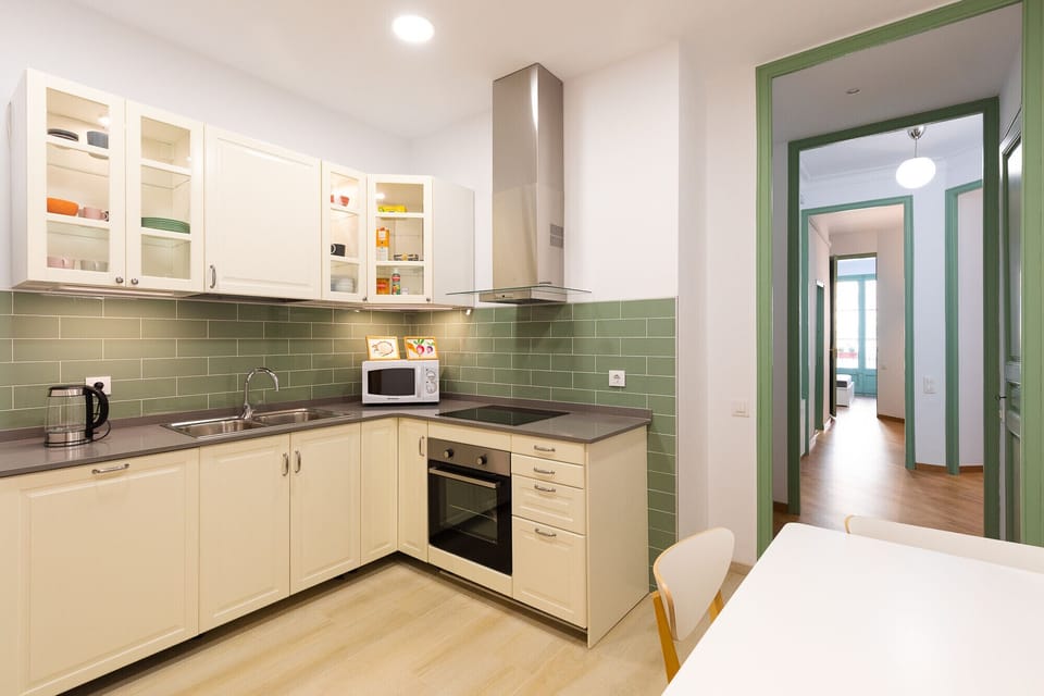 The kitchen of the Modernist Family Barcelona Holiday Apartment is fully equipped, with a refrigerator, oven, microwave, dishwasher, induction cooktops, kettle, juicer, coffee maker and toaster.