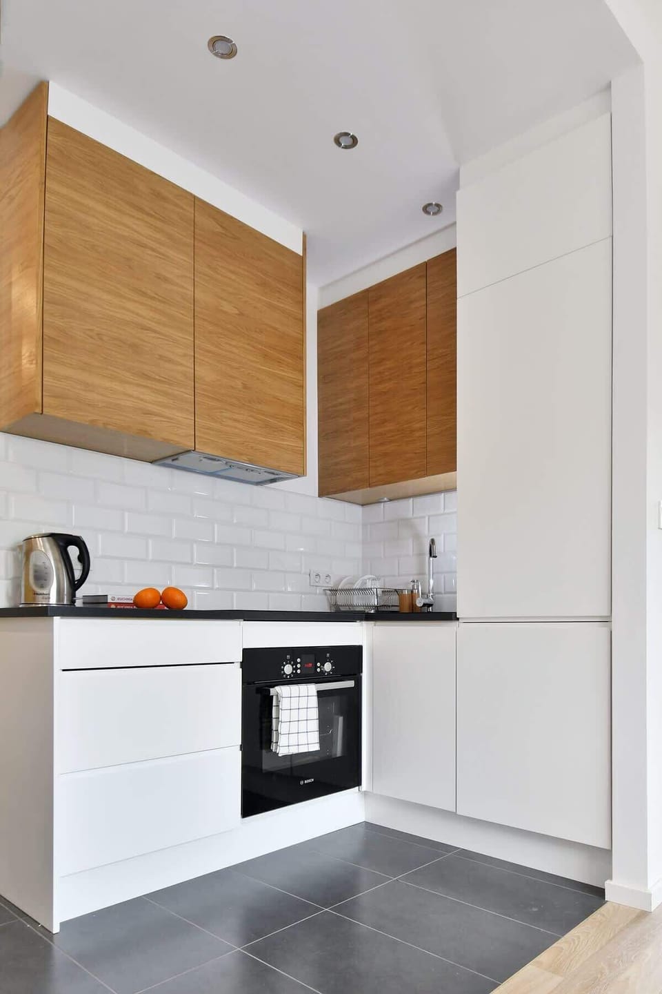 Modern kitchenette with a kettle, fridge freezer, induction hob, oven, toaster.