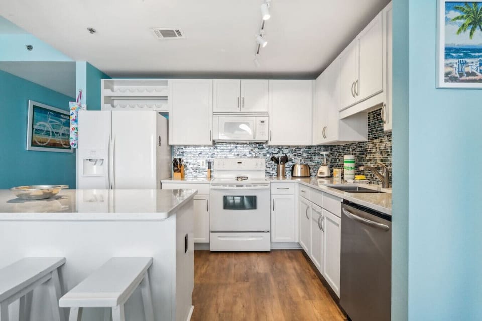 Fully stocked kitchen with island that has seating for 3 and a small dining area with seating for 3