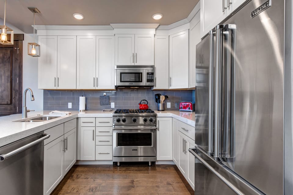 Gourmet Kitchen with Stainless Steel Viking Appliances, Stone Countertops, and Bar Seating for 3